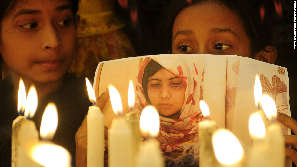 Pakistani supporters hold photographs of Malala as they stand alongside burning candles during a ceremony to mark Malala Day in Karachi on Saturday, November 10, 2012. The teen activist was shot in the head by the Taliban as she rode home from school in a van last month. She had defied the militant group by insisting on the right of girls to go to school. The attack has stirred outrage in Pakistan and around the world.