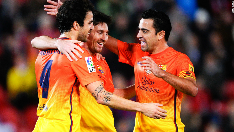 Lionel Messi, center, celebrates with Barcelona teammates Cesc Fabregas, left, and Xavi Hernandez after matching Pele&#39;s 75 goals in a calendar year.