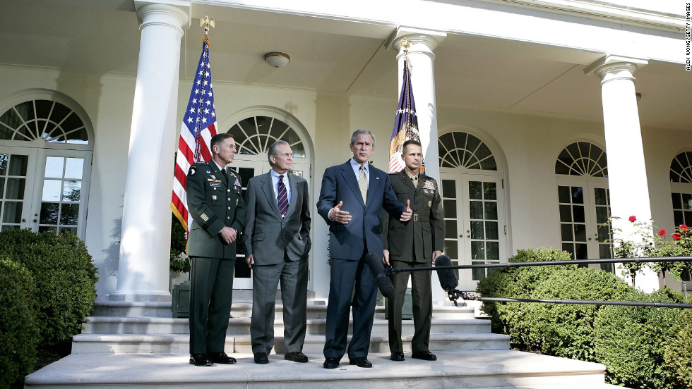 Lt. Gen. Petraeus, left, listens to President George W. Bush after Bush met with top military officials to discuss the war in Iraq in October 2005.