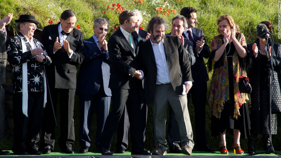 Skuespilleren Martin Freeman, til venstre, bliver hilst velkommen af instruktør Peter Jackson på scenen sammen med andre skuespillere ved verdenspremieren.