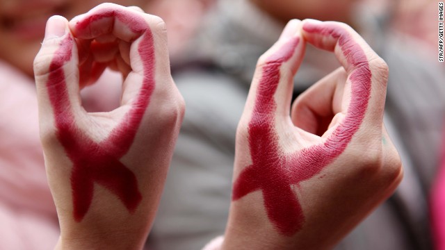 Chinese students show their hands painted to look like red ribbons for World AIDS Day 2012.