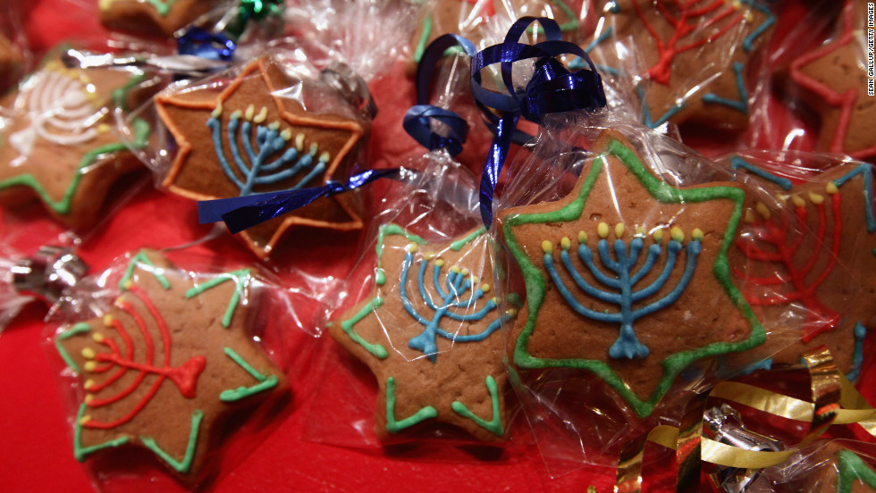 Gingerbread cookies in the shape of Stars of David and decorated with a Hanukkiah candelabrum.