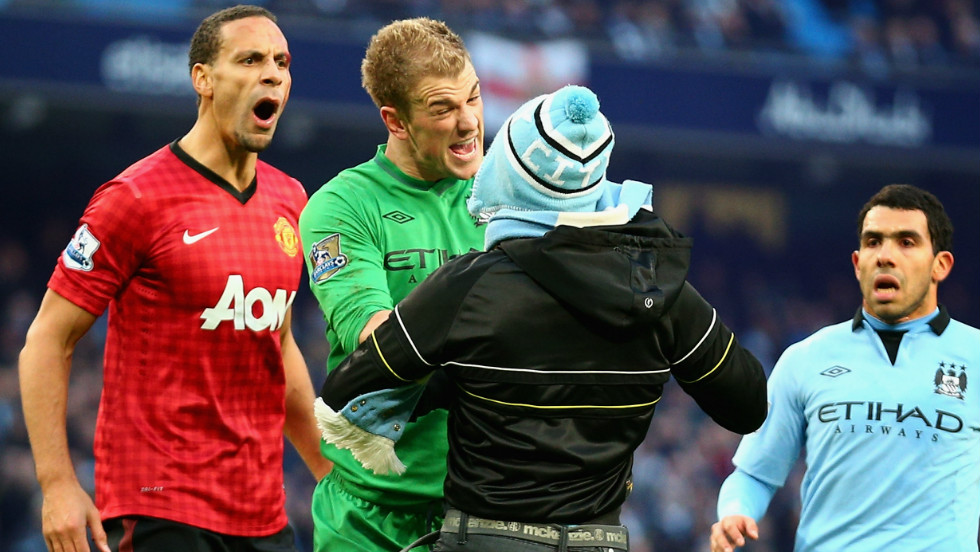 Manchester City goalkeeper Joe Hart confronts a pitch invader trying to harass Manchester United&#39;s Ferdinand, who had been hit in the face by a coin thrown from the crowd. 