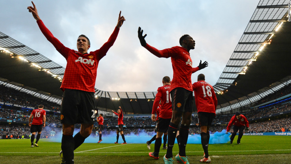 United&#39;s players celebrate Robin Van Persie&#39;s decisive late goal in a 3-2 victory -- which was met by missiles and smoke bombs hurled by City supporters.