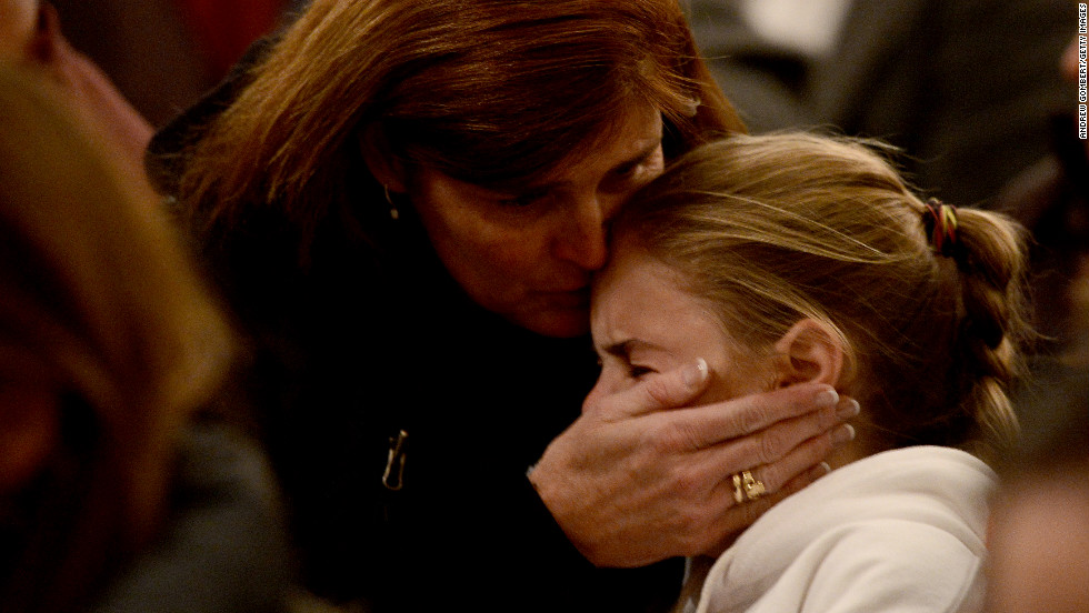 Women comfort each other during the vigil at St. Rose Church.