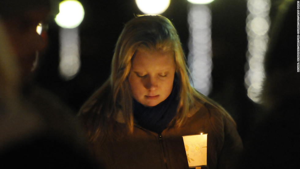 Corinne McLaughlin, a student at the University of Hartford, bows her head during a candlelight vigil at Hartford, Connecticut&#39;s Bushnell Park on Friday, December 14, honoring the students and teachers who died at Sandy Hook Elementary School in nearby Newtown earlier in the day.