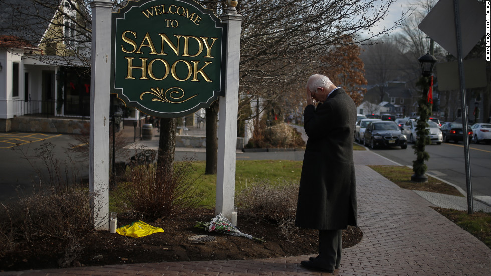 New Jersey resident Steve Wruble, who was moved to drive out to Connecticut to support local residents, grieves for victims at the entrance to Sandy Hook village in Newtown on Saturday.