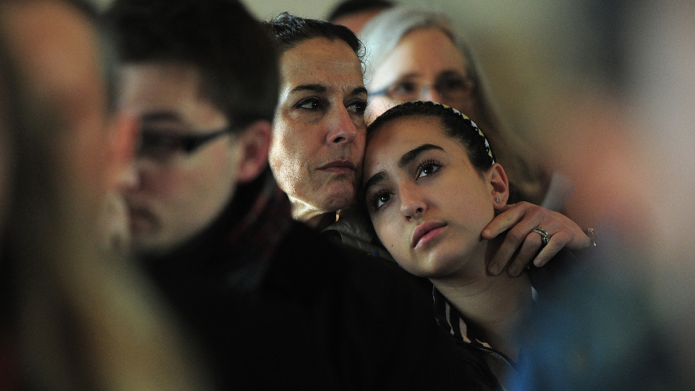 A mother and daughter attend a prayer service at St. John&#39;s Episcopal Church in Newtown on Saturday.