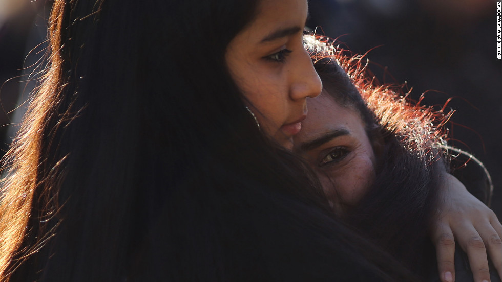 Claudia Urbiana and daughter Jocelyne Cardenas, left, hug outside of the entrance to the Sandy Hook school.
