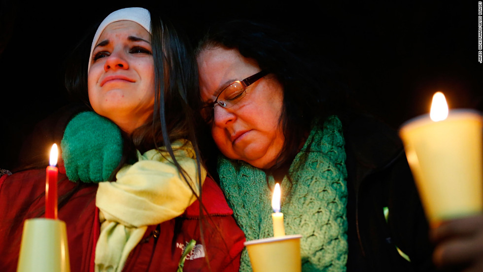 Donna Soto, right, mother of Victoria Soto, the first-grade teacher at Sandy Hook Elementary School who was shot and killed while protecting her students, hugs her daughter Karly while mourning their loss at a candlelight memorial at Stratford High School on Saturday, December 15, in Stratford, Connecticut.