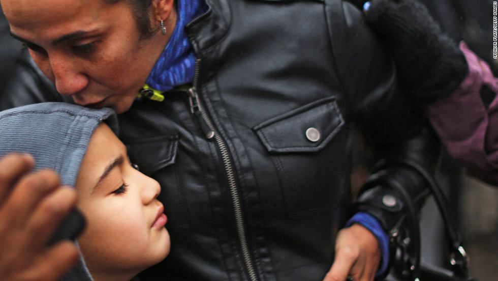 Ty Diaz is kissed by his mother, Yvette, at a memorial down the street from Sandy Hook on December 16.