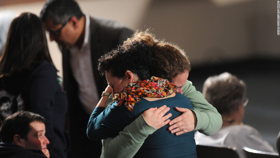 Two women embrace before the interfaith vigil at Newtown High School on Sunday evening. 