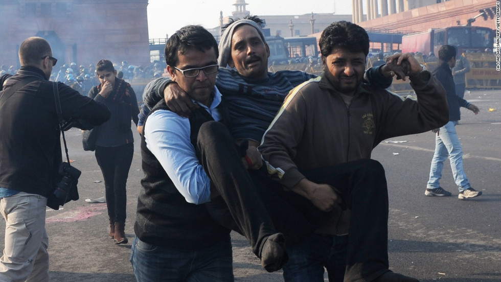 Indian demonstrators carry an injured man from the scene on December 22.