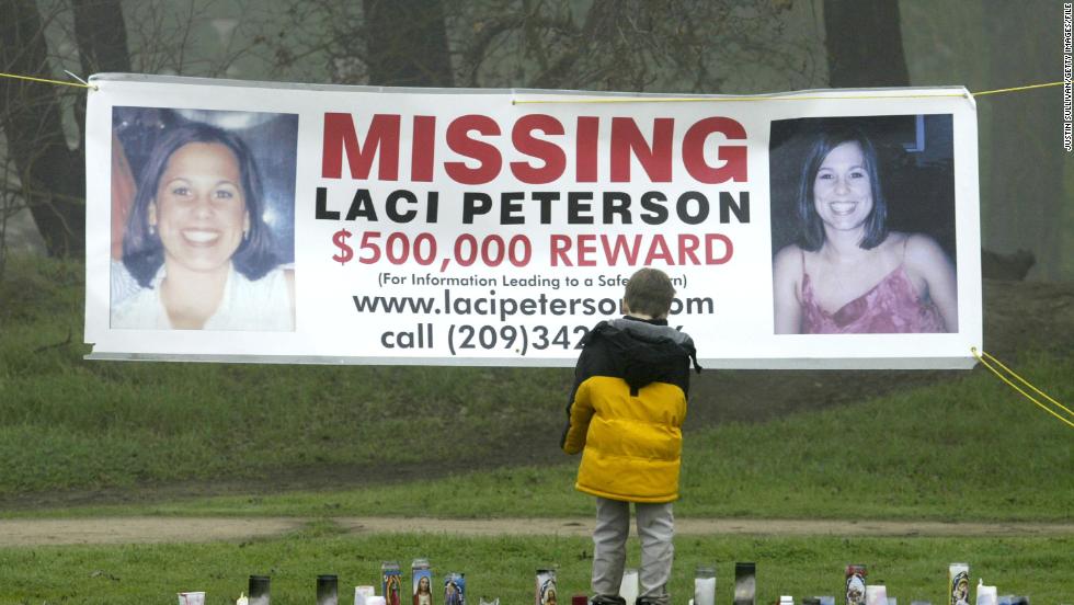 A young child stops to look at a makeshift memorial and a missing person&#39;s banner offering a half-million dollar reward for the safe return of Laci Peterson at the East La Loma Park  in Modesto, California, on January 4, 2003. 