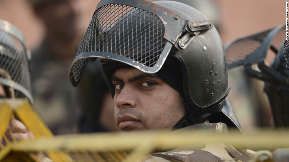 Riot police keep watch along a sealed-off road near the India Gate monument on Monday, December 24, in New Delhi after weekend clashes between protesters and police.