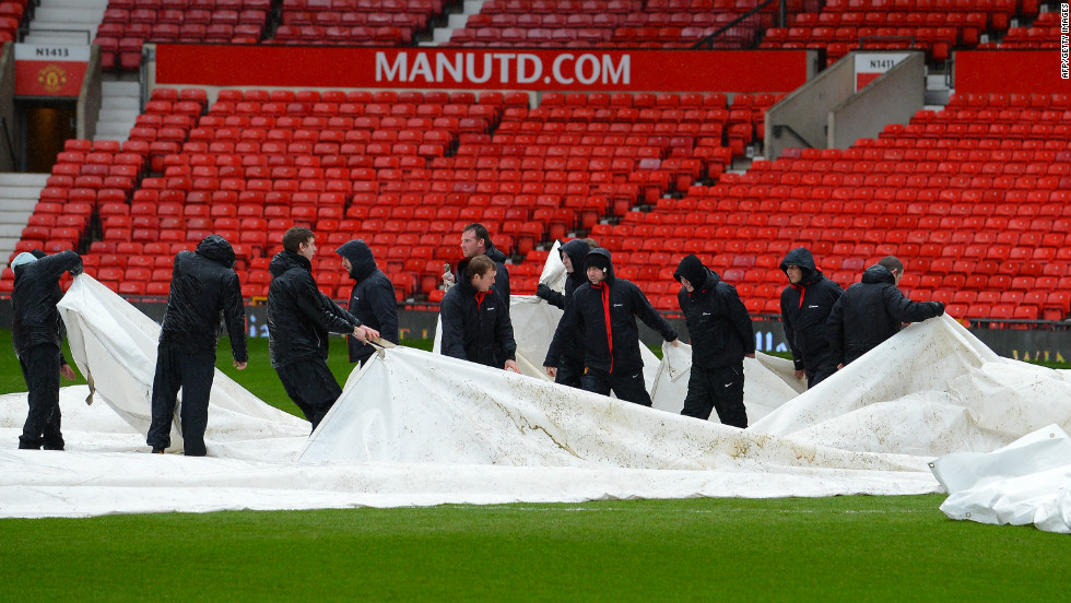 The match was cleared to go ahead after a late pitch inspection following days of rain in the UK. Groundstaff remove waterproof covers which protected the playing surface.