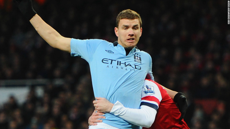 Second-placed Manchester City won 2-0 at Arsenal, who had defender Laurent Koscielny sent off in the ninth minute for this rugby tackle on Edin Dzeko.