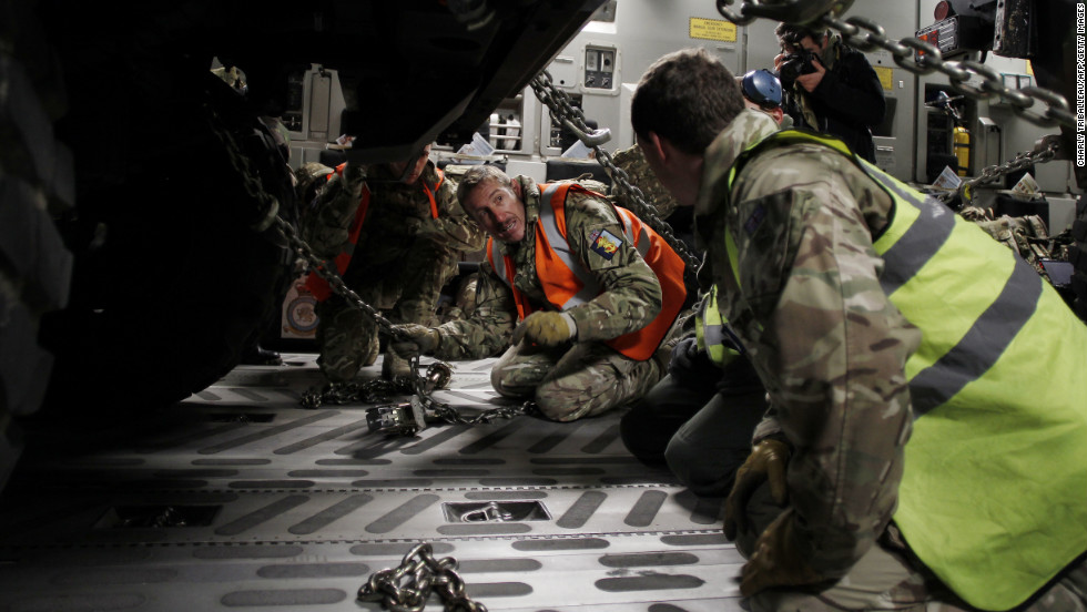 Workers adjust chains on a vehicle load in the C-17 in Evreux on Sunday.