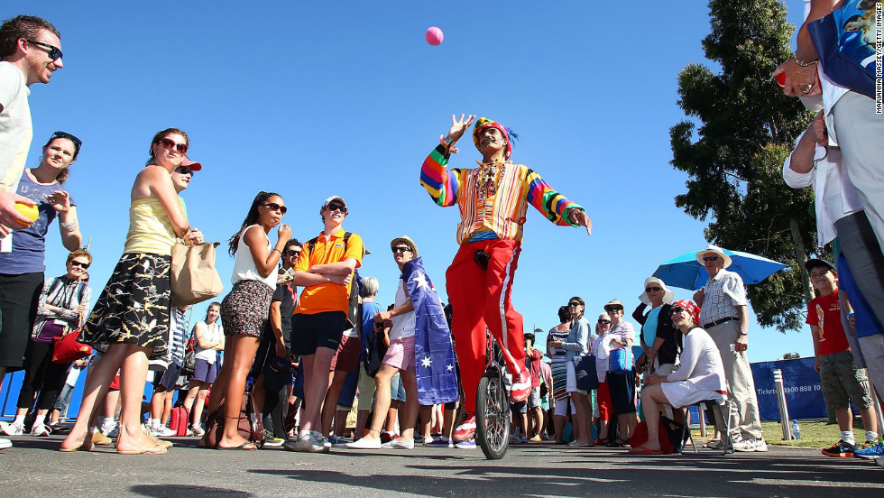 A juggler entertains the crowd as they wait to enter the grounds at Melbourne Park for Day 2 of the Australian Open.