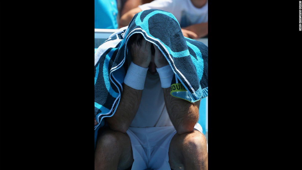 Brian Baker of the United States covers his head after injuring his knee in his second round match against compatriot Sam Querrey on January 16. After winning the first set in a tie breaker, Baker dropped out of the match two games into the second set.