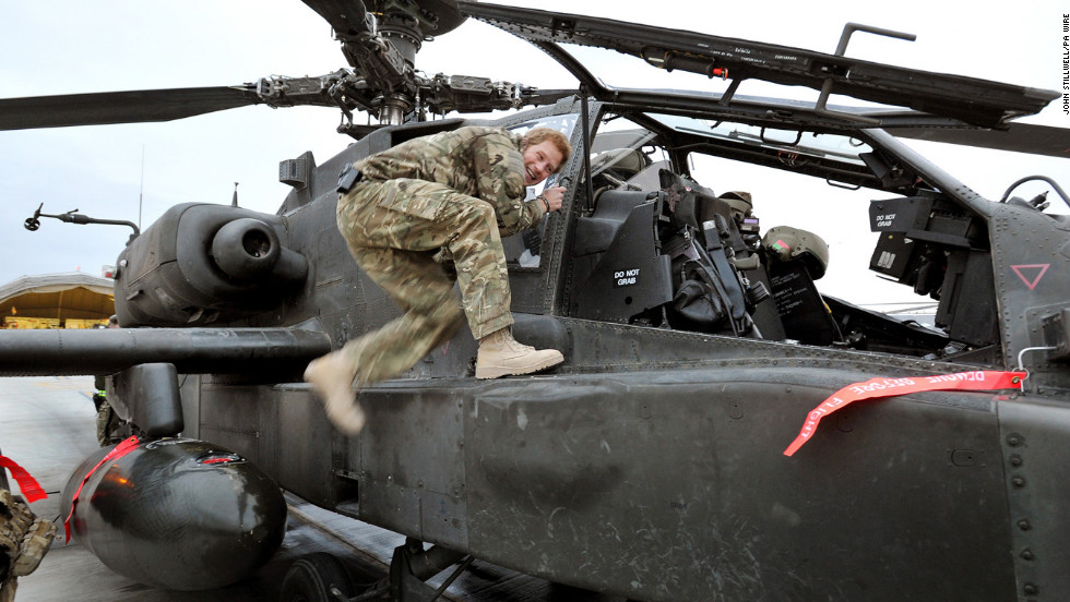 Harry climbs on board an Apache helicopter as part of a preflight check on December 12, 2012.