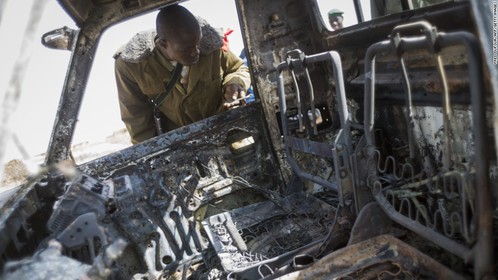 A Malian soldier looks at the wreckage of an Islamist rebel&#39;s armed pickup truck in Konna.