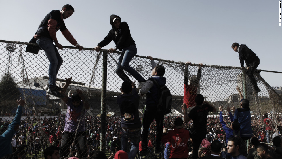 Egyptians climb over a fence at the Al-Ahly home stadium on January 26 in Cairo.