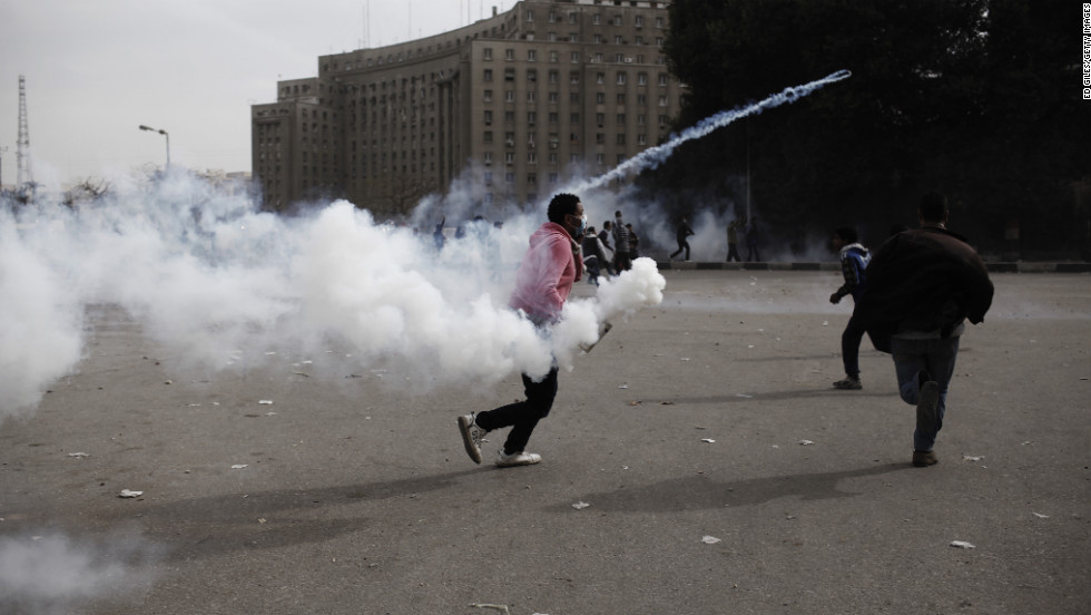 A protester throws a tear gas canister toward riot police in Cairo&#39;s Tahrir Square on Sunday, January 27. 