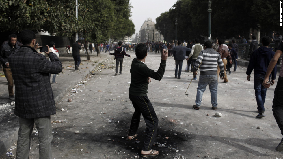 A protester throws a rock toward opposing demonstrators on January 27 in Cairo.