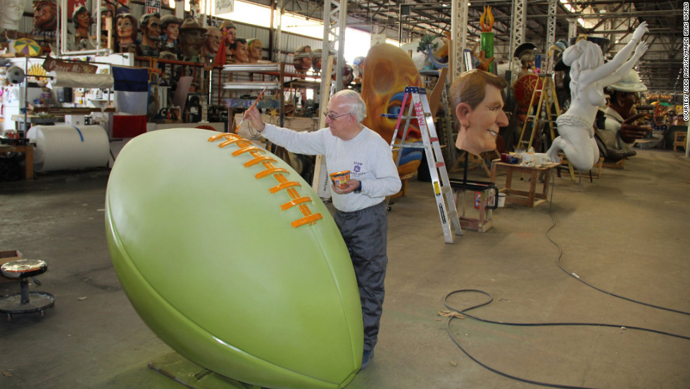 Workers at Mardi Gras World put the finishing touches on football-themed floats.