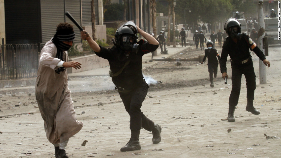 A riot police officer clashes with a protester near Cairo&#39;s Tahrir Square on January 28.