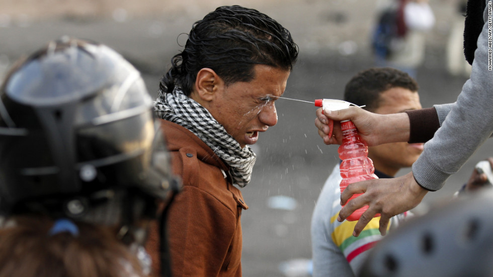 A protester sprays water into the eyes of a man after his exposure to tear gas during clashes with police near Cairo&#39;s Tahrir Square on Tuesday, January 29.