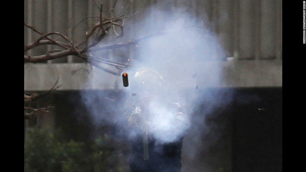 A police officer fires a tear gas canister during clashes with protesters near Tahrir Square on January 30.