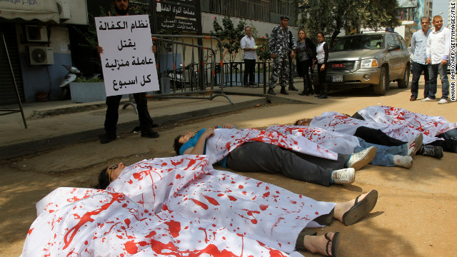 Activists participating in a flash mob don bloodied sheets as they lie in the streets outside the Ministry of Labour in Beirut to protest over violence against migrant workers in April 2012. 