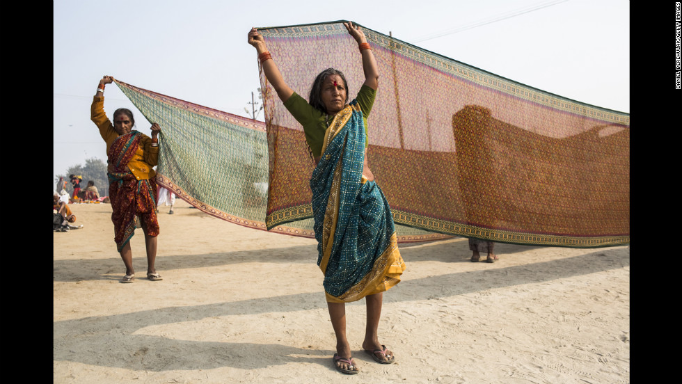 A Hindu devotee holds out a saree to dry after having bathed on the banks of the Ganges river on January 13.