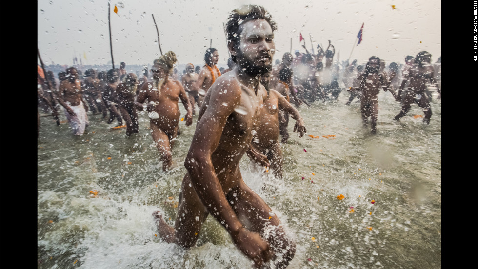 Naga Sadhus run into the waters of the Ganges River during the bathing day of the Maha Kumbh Mela on January 14.