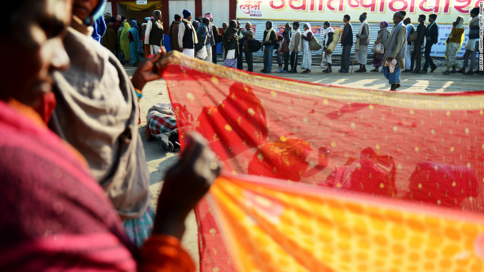 Devotees line up to receive a free meal near women drying saris on February 8.