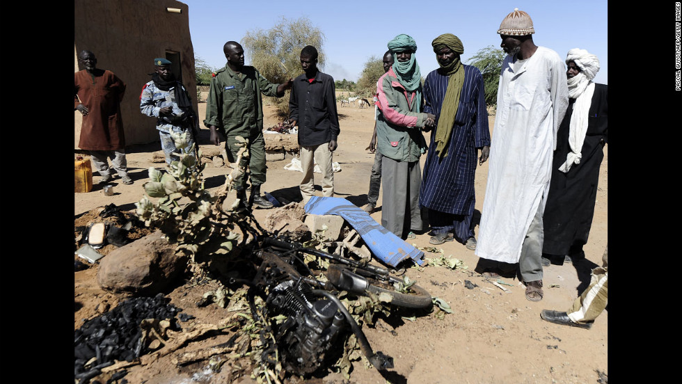 Malians look at the charred motorcycle used by a suicide bomber before he blew himself up near a group of Malian soldiers on February 8. The act marked the first suicide attack in the embattled west African nation since the start of a French-led offensive to oust the Islamists from Mali&#39;s north, where they had controlled key towns for 10 months.