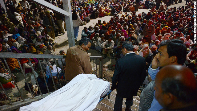 Indian authorities remove the body of a person  killed during a stampede at the railway station in Allahabad on Sunday.