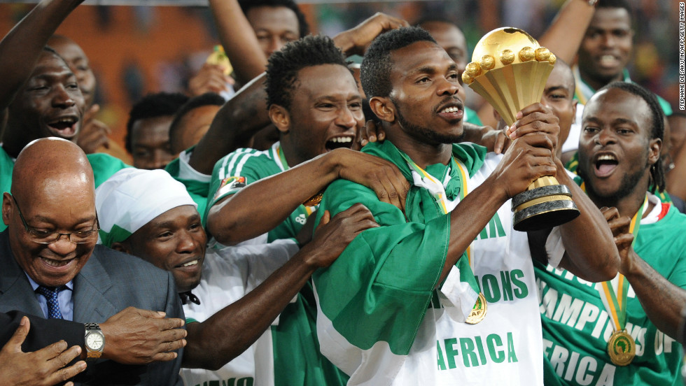 Nigeria&#39;s captain Joseph Yobo holds the Africa Cup of Nations trophy, which had been handed to him by South African President Jacob Zuma (L) at Soccer City stadium in Johannesburg.