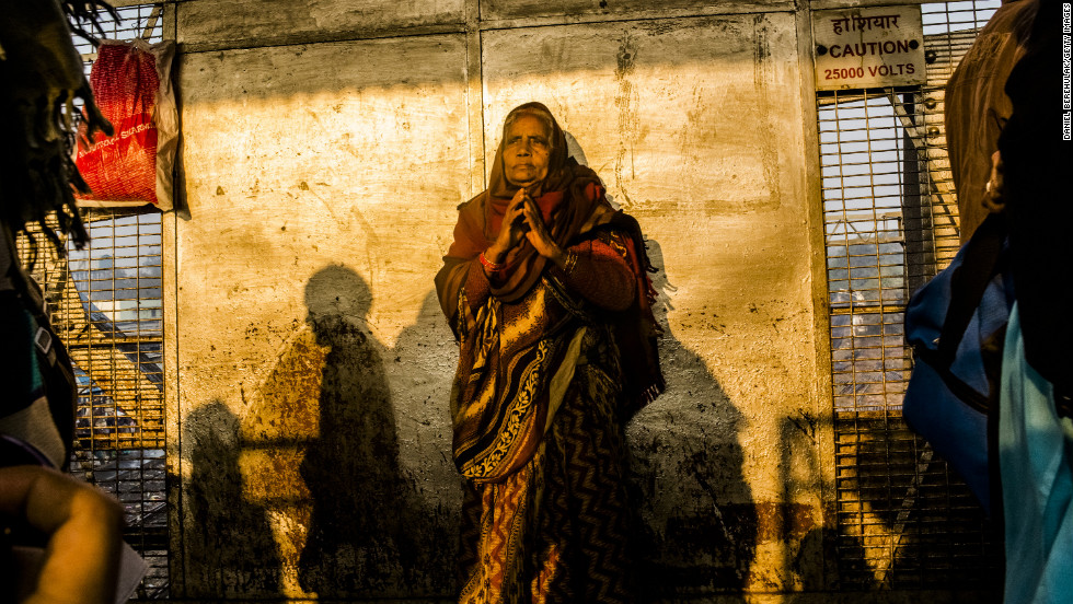 A Hindu devotee waits on February 11 as people move through the site of Sunday&#39;s stampede in Allahabad, India. Tens of millions of Hindu pilgrims flock to the banks of the Ganges River for what is thought to be the world&#39;s largest religious gathering.