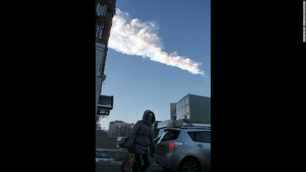 The meteor&#39;s vapor trail passes over the city. 
