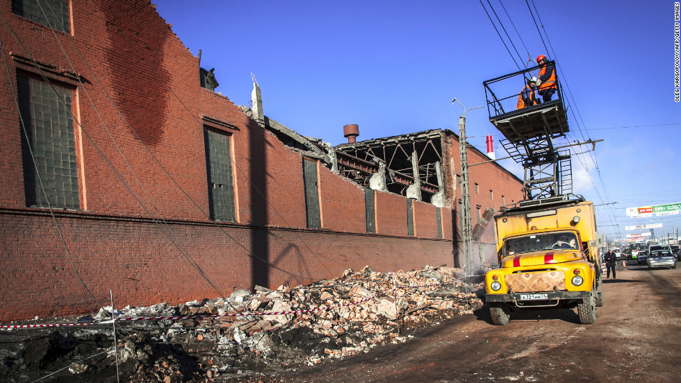 Workers repair a damaged power line near the wall of a local zinc plant. About 270 buildings were damaged -- mostly broken glass -- by shock waves caused by the blast, said Vladimir Stepanov of the National Center for Emergency Situations at the Russian Interior Ministry.