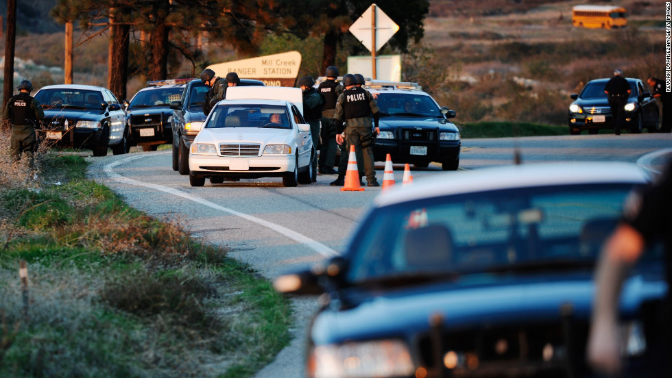 Police search cars at a blockade as they come down off the mountain during a manhunt for Dorner on February 12.