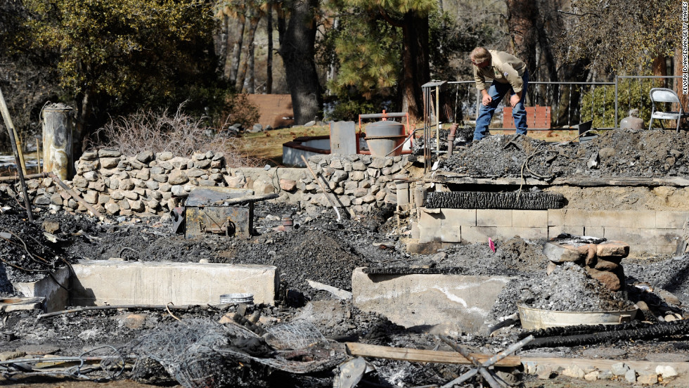 An employee of Southern California Edison surveys the damage at the burned-out cabin where the remains of multiple-murder suspect and former Los Angeles Police Department officer Christopher Dorner were found on Friday, February 15, in Big Bear, California.
