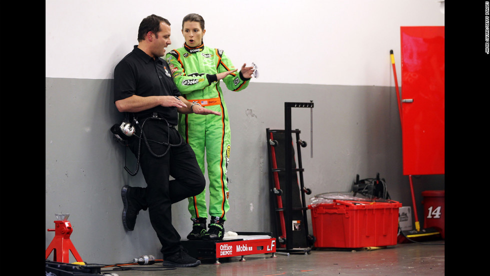 Patrick speaks to a crew member in the garage at Daytona International Speedway in 2012.