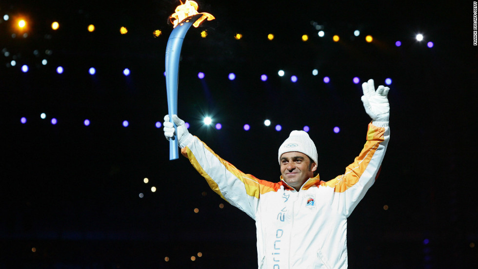 Tomba carries the Olympic torch into the stadium at the opening ceremony for the 2006 Winter Games in Turin. 