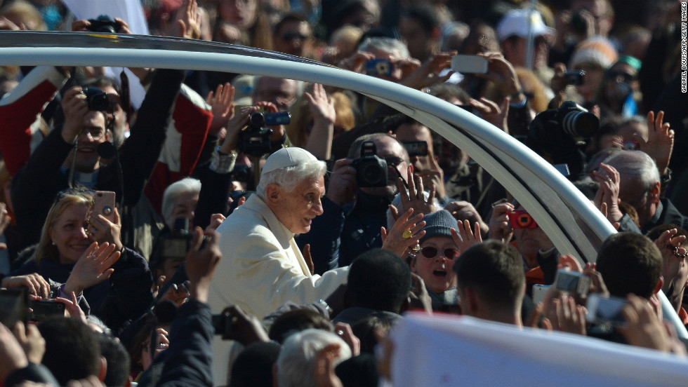 Benedict waves from to the crowd as he arrives at St. Peter&#39;s Square.
