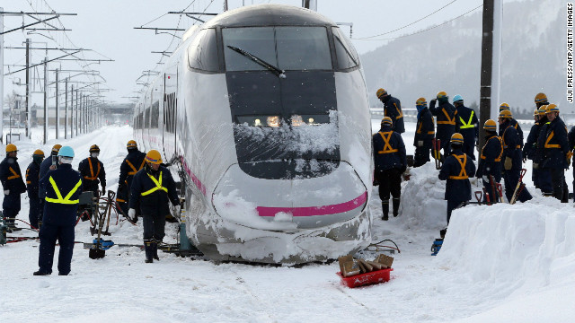 Railway workers inspect a bullet train Sunday after it derailed during its journey from Tokyo to northern Japan.