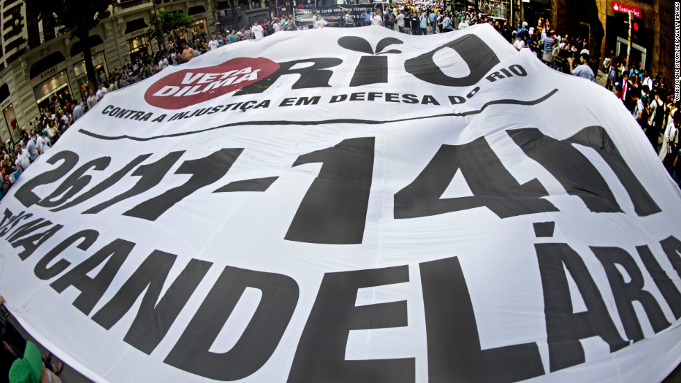 People hold a huge banner during a demonstration demanding that Brazilian President Dilma Roussef veto a bill that would redistribute oil royalties in favor of non-oil producing states.